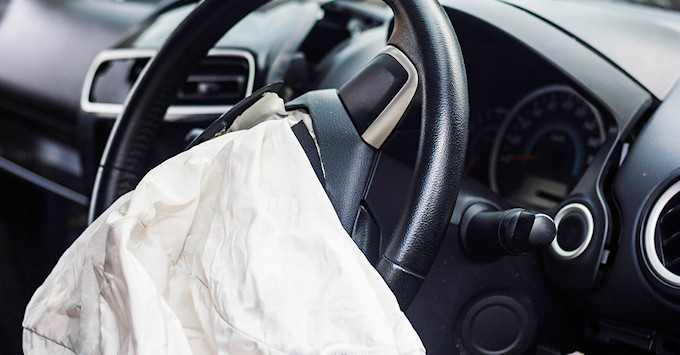 steering wheel of vehicle with deployed airbag that is now deflated