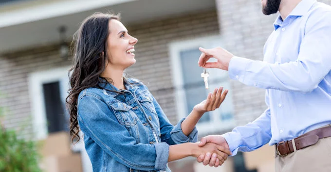 airbnb renter giving homeowner a handshake and receiving keys for the rental