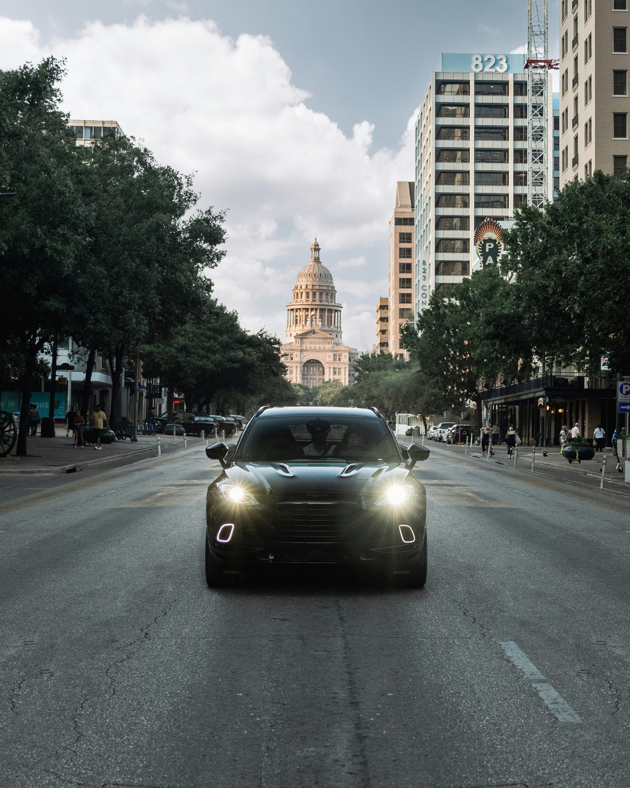 black porsche driving in front of Texas state capital building in Austin, TX